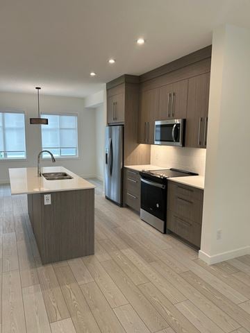 Calgary house for rent - A modern kitchen with wooden cabinets and stainless steel appliances.