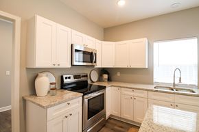 Little Rock house for rent - A kitchen with white cabinets and a granite countertop.