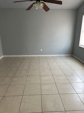 Deltona house for rent - A room with a ceiling fan and tile flooring.
