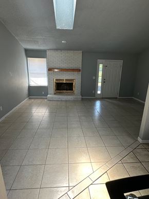 Deltona house for rent - A living room with a fireplace and tile flooring.