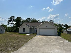 Deltona house for rent - A house with a garage and a driveway in front of it.