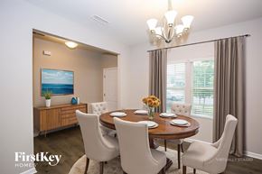 Statesville house for rent - A dining room with a wooden table and chairs, a chandelier, and a painting on the wall.