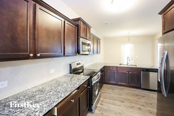 Statesville house for rent - A kitchen with wooden cabinets and a granite countertop.
