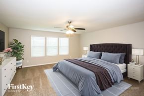 Statesville house for rent - A bedroom with a large bed and a ceiling fan.