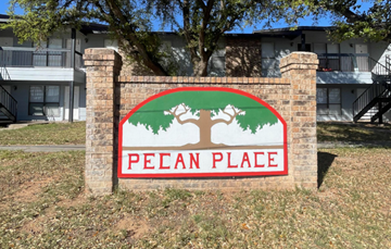 Monahans apartment for rent - A sign that says Pecan Place in front of a building.