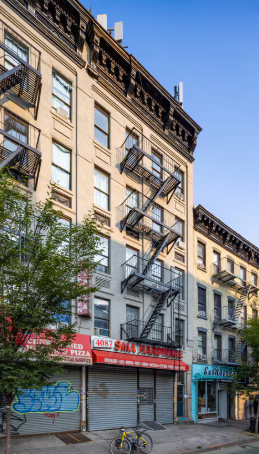 New York apartment for rent - A building with a red awning and a closed shuttered window.