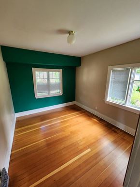 Victoria apartment for rent - A room with wooden floors and a window with blinds.