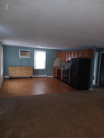 North Providence apartment for rent - A kitchen with a black refrigerator and wooden cabinets.
