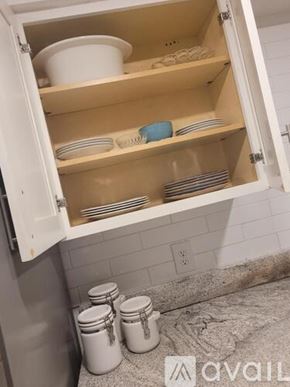 Daytona Beach house for rent - A kitchen cabinet is open, revealing plates and bowls inside.