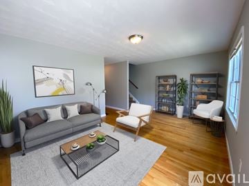 Providence house for rent - A living room with a grey couch, a coffee table, and a painting on the wall.