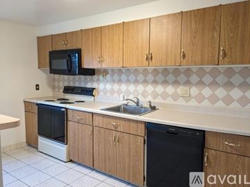 Halethorpe house for rent - A kitchen with wooden cabinets and a black microwave above the stove.