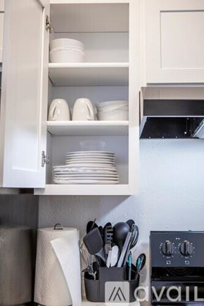 Sierra Vista apartment for rent - A kitchen cabinet is open, revealing plates and bowls inside.