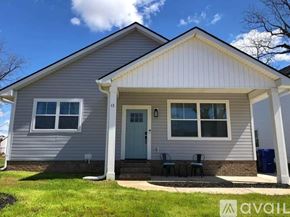 Greenville house for rent - A house with a grey siding and a white door is for sale.