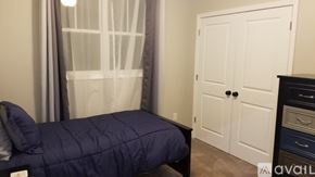 Greenville house for rent - A bedroom with a bed covered in a blue comforter.