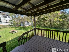 Asheville apartment for rent - A wooden deck with a view of a backyard and trees.