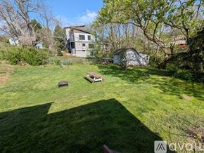 Asheville apartment for rent - A backyard with a lawn, a fire pit, and a tree.