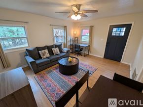 Asheville apartment for rent - A kitchen with white cabinets and a black stove top oven.