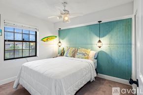 Delray Beach condo for rent - A bedroom with a white bed and a ceiling fan.