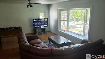 Saint Paul apartment for rent - A living room with a brown leather couch and a television.