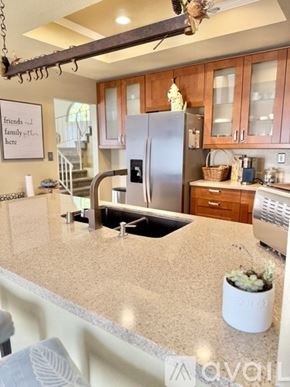 San Dimas townhouse for rent - A kitchen with a bar stool and a couch with a pillow that says "love".