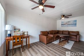 Odessa apartment for rent - A living room with a brown leather couch, a wooden table, and a ceiling fan.