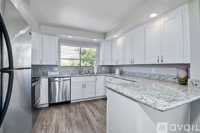Carlsbad apartment for rent - A kitchen with white cabinets and a granite countertop.