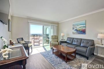 Carlsbad apartment for rent - A living room with a leather couch, a wooden coffee table, and a painting on the wall.