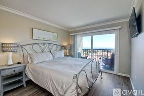 Carlsbad apartment for rent - A bedroom with a large bed and a balcony overlooking the ocean.