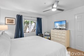 Oceanside apartment for rent - A patio with a table and chairs overlooks a row of apartment buildings.