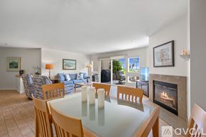 Oceanside apartment for rent - A bedroom with a large bed, a dresser with a flat screen TV, and a ceiling fan.