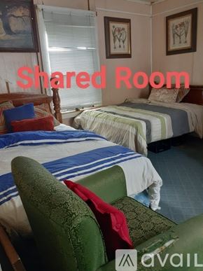 Marrero house for rent - A room with two beds and a green chair is labeled as a shared room.