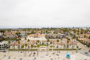 Oceanside apartment for rent - A beachfront area with a row of buildings and palm trees.