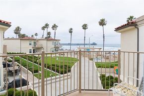 Oceanside apartment for rent - A view from a balcony overlooking a pool and beach.