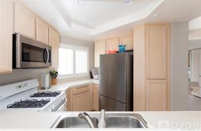 Oceanside apartment for rent - A kitchen with a stove, microwave, and refrigerator.