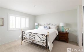 Oceanside apartment for rent - A bedroom with a large bed and a carpeted floor.
