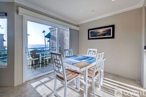 Oceanside apartment for rent - A dining room with a table and chairs and a view of the outside.