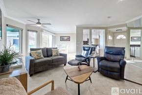 Oceanside apartment for rent - A living room with a grey couch, a brown coffee table, and a blue recliner.