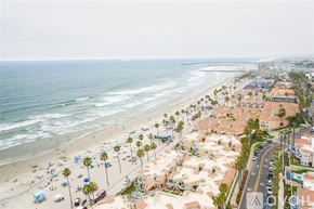 Oceanside apartment for rent - A beachside town with palm trees and a clear sky.
