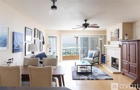 Oceanside apartment for rent - A living room with a table, chairs, and a fireplace.