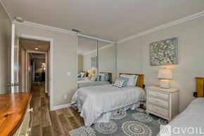 Oceanside house for rent - A bedroom with a large bed and a mirrored wall.