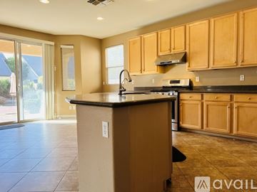 Gilbert house for rent - A kitchen with wooden cabinets and a black countertop.