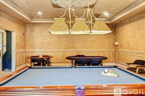 East Moriches apartment for rent - A pool table in a room with a chandelier.