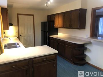 Knoxville apartment for rent - A kitchen with brown cabinets and a black refrigerator.