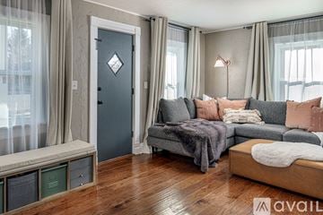 Colorado Springs house for rent - A living room with a grey couch and a grey blanket on it.
