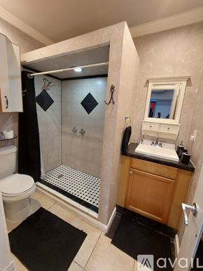 Hialeah house for rent - A small building with a brown roof and a white door is situated in a grassy area.