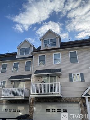 Stamford apartment for rent - A two-story building with a balcony and a garage door.