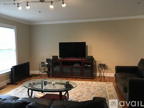 Stamford apartment for rent - A living room with a glass coffee table and a television.