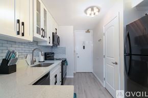 Honolulu apartment for rent - A kitchen with white cabinets and a black refrigerator.