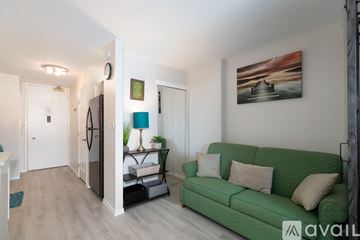 Honolulu apartment for rent - A living room with a green couch and a painting on the wall.