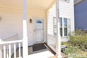 Raleigh apartment for rent - A white house with a black mat on the porch.
